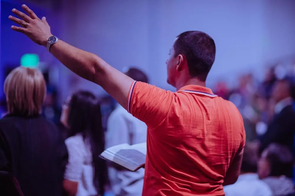 man with bible and raised arm